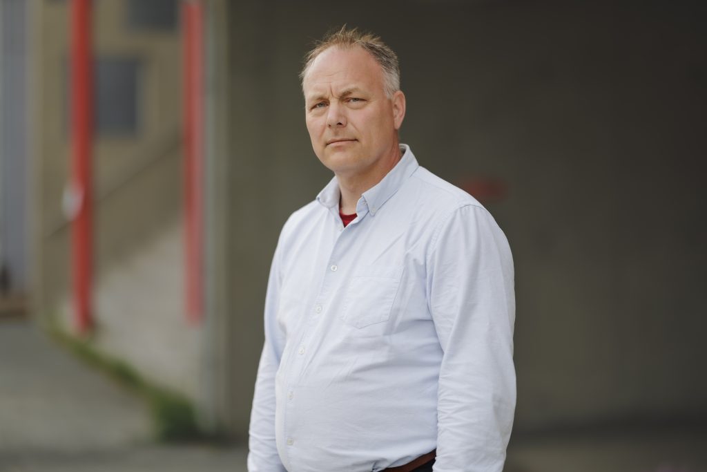 portrettbilde Pål Julius Skogholt med blå skjorte og uklar bakgrunn